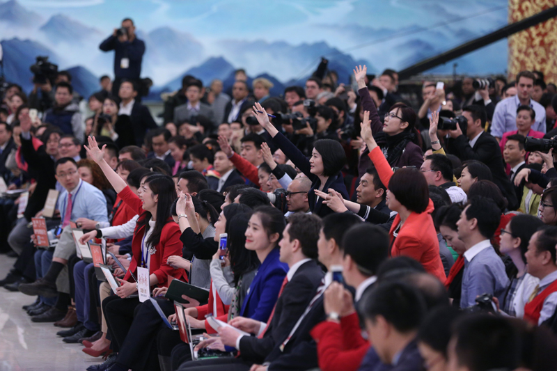 3月15日，國務院總理李克強在北京人民大會堂與中外記者見面，并回答記者提問。這是記者舉手爭取提問機會。 新華社記者 才揚 攝